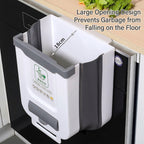 A white and gray collapsible under-the-sink trash can shown mounted on a kitchen sink. The image includes English text overlays explaining the large opening design and anti-fall feature, with a 18cm depth measurement arrow.