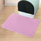 Pink mat on a wooden floor in front of a cat litter box
